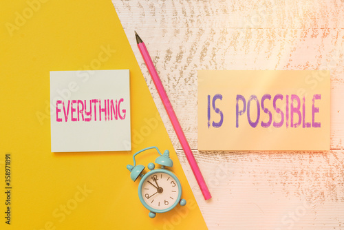 Handwriting text writing Everything Is Possible. Conceptual photo Being optimistic that all of your dream will come true Notepads marker pen colored paper sheet alarm clock wooden background