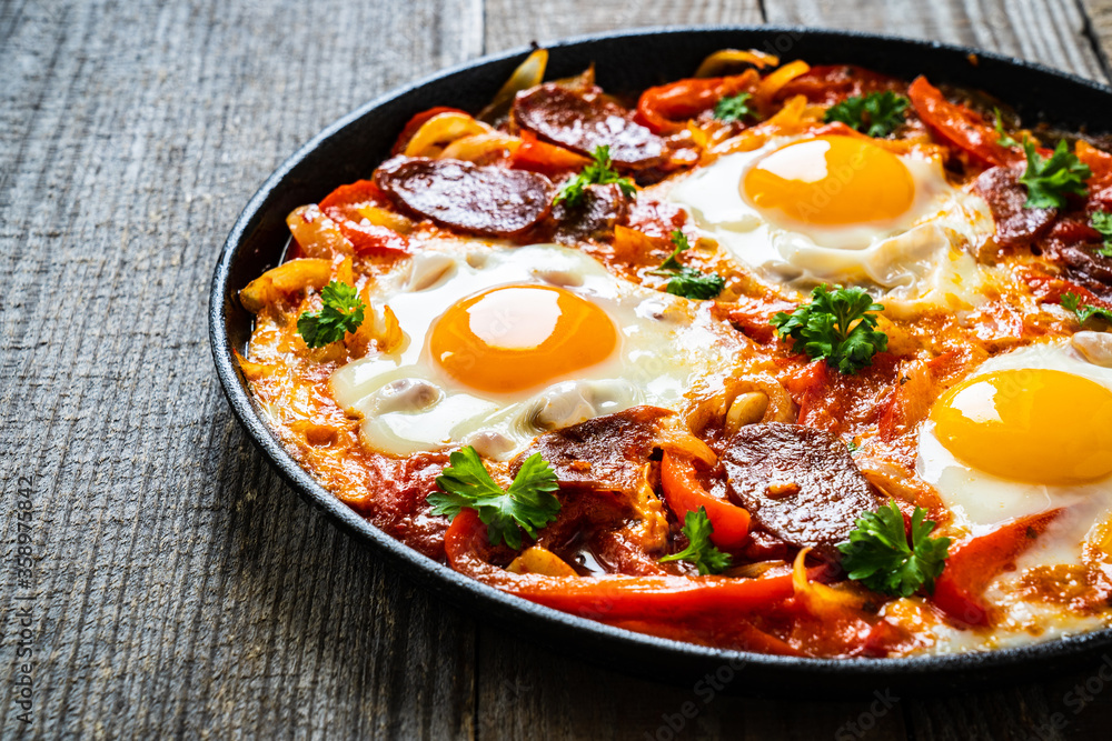 Shakshuka - fried eggs with chorizo and vegetables in frying pan
Shakshuka - fried eggs with chorizo and vegetables in frying pan
