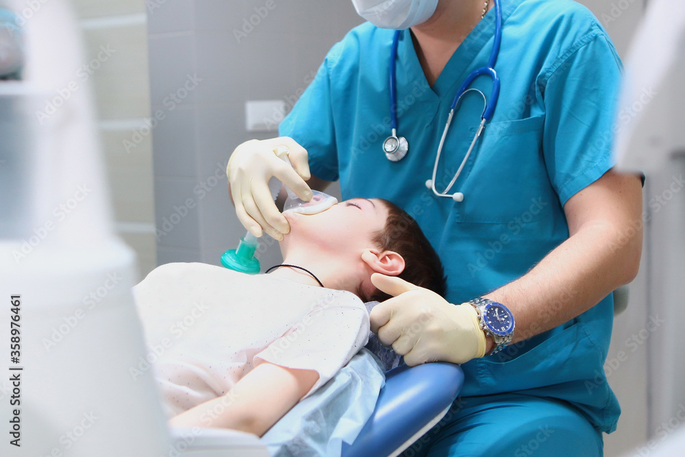 The resuscitator enters the boy under anesthesia before the operation. Concept of health care and life saving. Copy of the space. The resuscitator enters the boy under anesthesia before the operation. Concept of health care and life saving. Copy of the space.