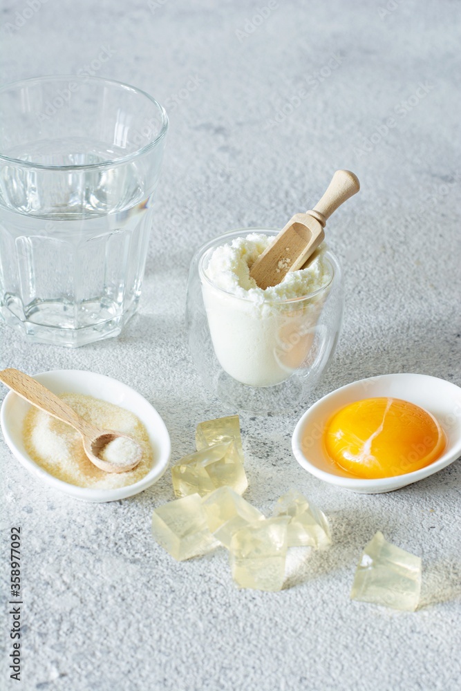 Products (collagen powder, gelatin, yolk) which contain collagen.Diced gelatin.Collagen powder on a light background. Extra protein intake. Natural beauty and health supplement for skin, bones, joints Products (collagen powder, gelatin, yolk) which contain collagen.Diced gelatin.Collagen powder on a light background. Extra protein intake. Natural beauty and health supplement for skin, bones, joints