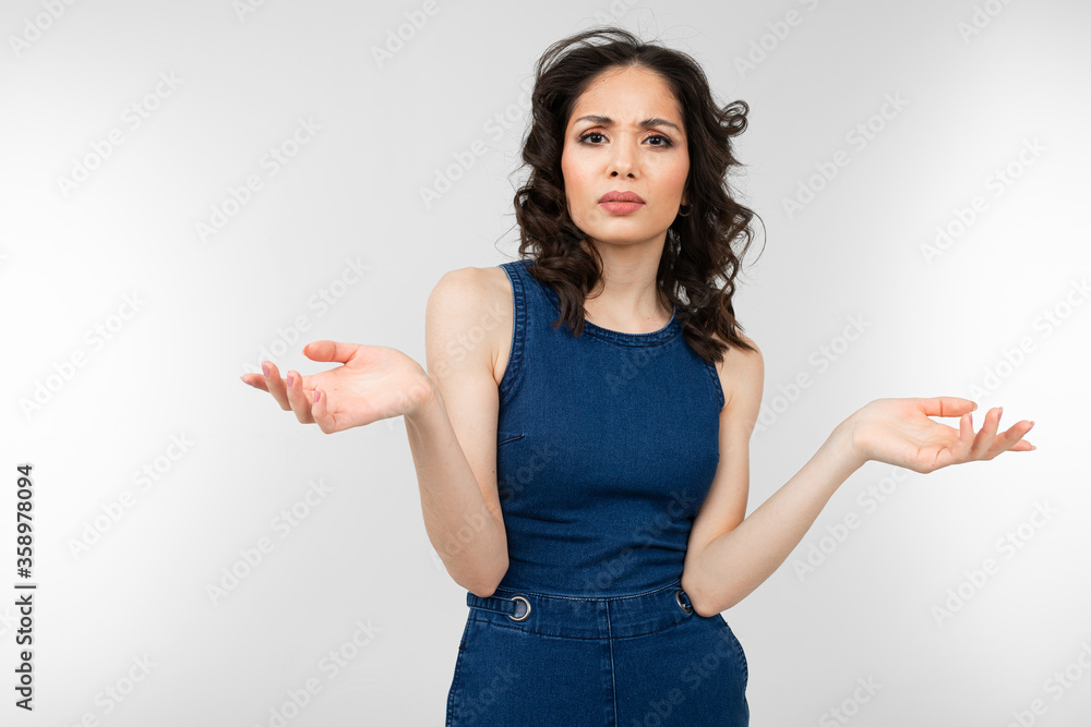 stylish woman in summer blue jeans waving arms on a white background with copy space stylish woman in summer blue jeans waving arms on a white background with copy space