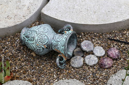 Decorative jug colored pebbles garden decoration photo