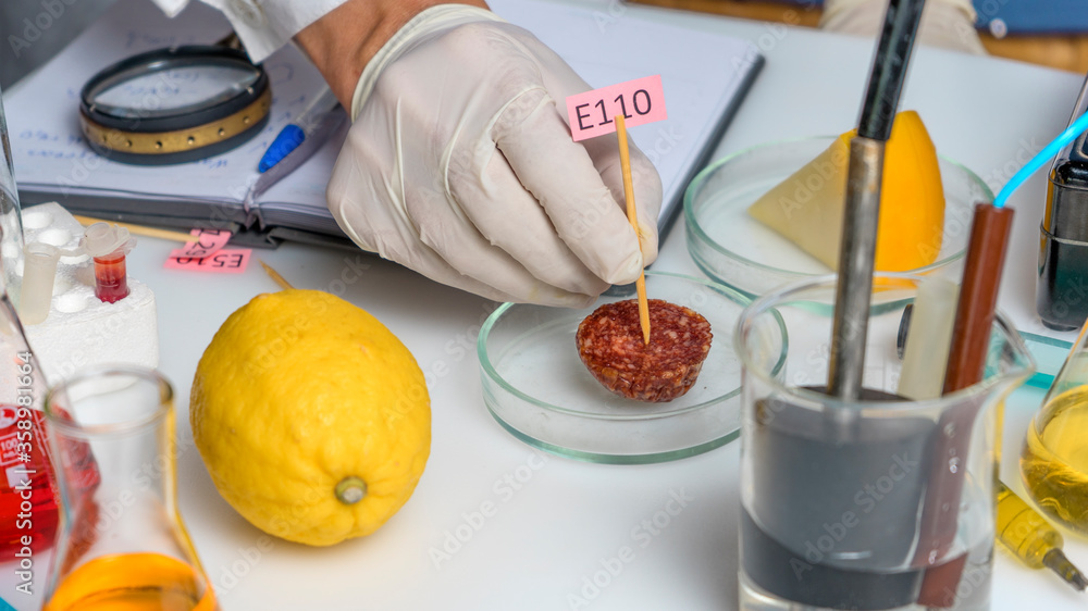 Healthy eating concept. The laboratory assistant s hand holds a tablet with the names of the additives of E. Food Laboratory. Healthy eating concept. The laboratory assistant s hand holds a tablet with the names of the additives of E. Food Laboratory.
