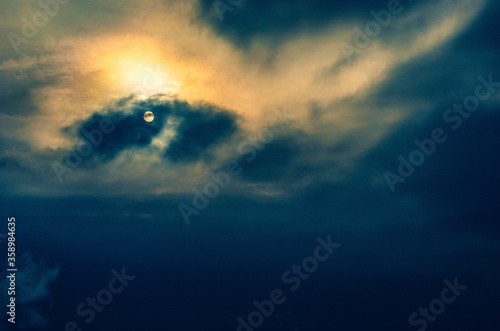 Peaceful twilight scene - sky with clouds and partly hidden sun ball