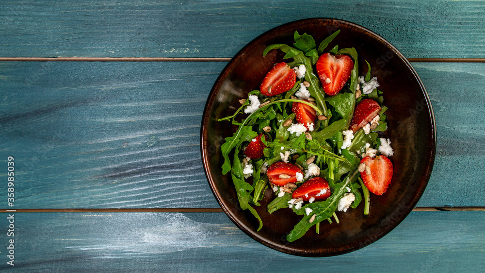 Spring salad with arugula, strawberries and ricotta. Food recipe background. space for text. top view.