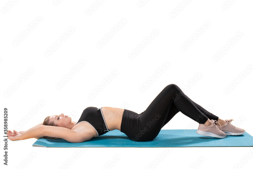 Fitness Frau, jung, sportlich, Yoga, liegend auf einer Yogamatte mit Sportklamoten, Sportanzug, Liegematte Fitness Frau, jung, sportlich, Yoga, liegend auf einer Yogamatte mit Sportklamoten, Sportanzug, Liegematte