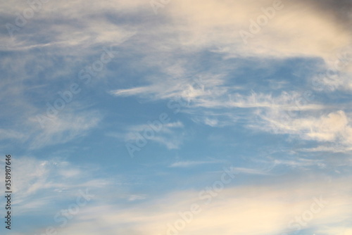White fluffy clouds on a background of blue sky in summer. The concept of weather and climate.