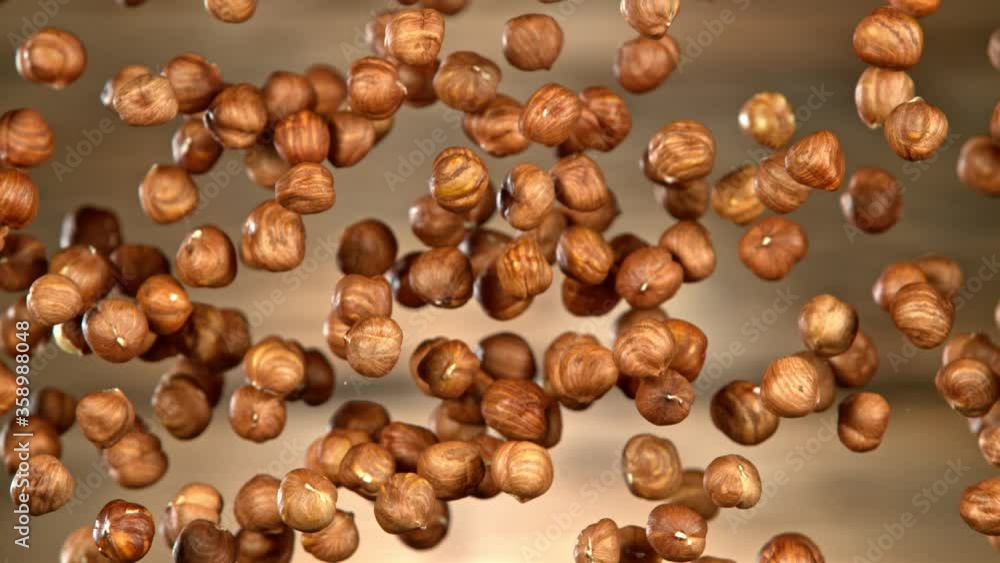 Super Slow Motion Shot of Flying Hazelnuts After Being Exploded on Wooden Background at 1000 fps. Super Slow Motion Shot of Flying Hazelnuts After Being Exploded on Wooden Background at 1000 fps.