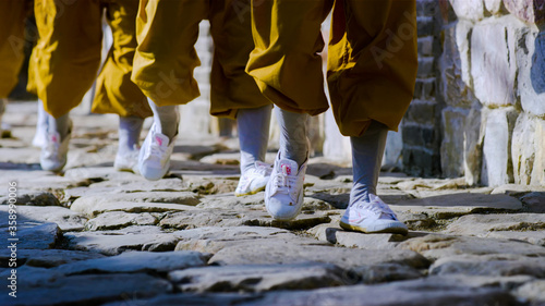 A group of children monks training kungfu in Shaolin Monastery walking. Dengfeng, Zhengzhou, Henan, China 