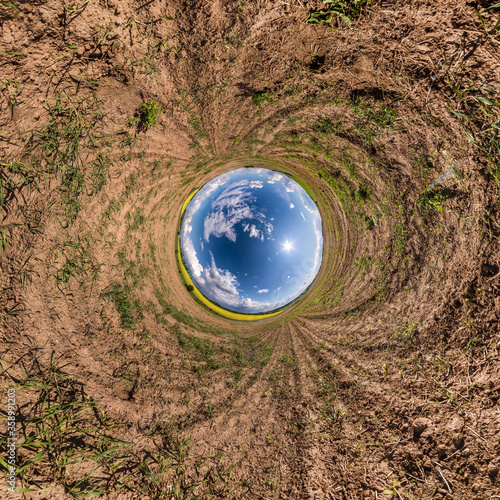Inversion of little planet transformation of spherical panorama 360 degrees. Spherical abstract aerial view in field with awesome beautiful clouds. Curvature of space.