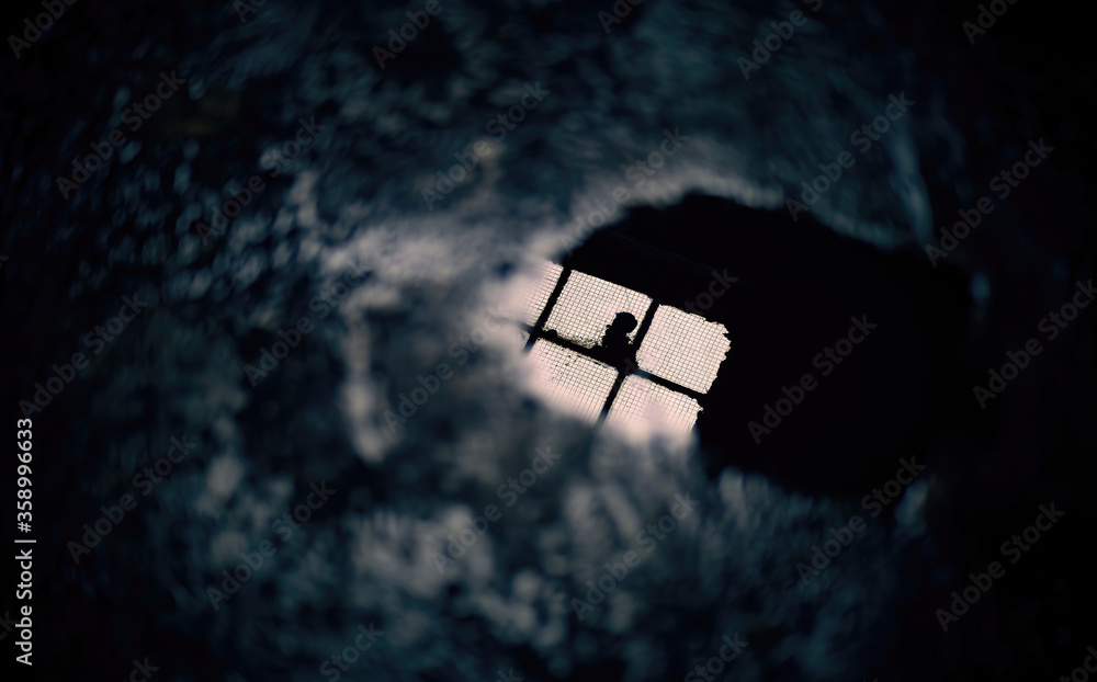 Reflection of a window in a puddle of water on the floor in a gloomy dark atmosphere Reflection of a window in a puddle of water on the floor in a gloomy dark atmosphere
