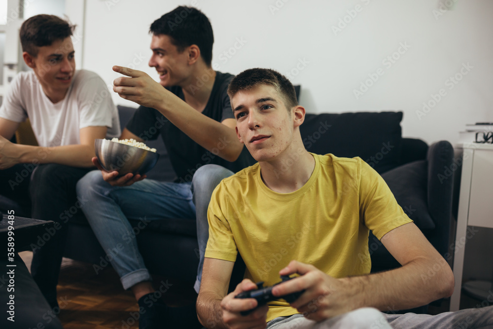teenager boys having fun playing games on console at home teenager boys having fun playing games on console at home