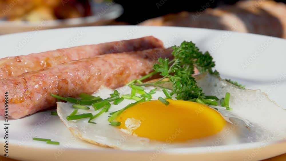 Close-up of the white plate with fried sausages and eggs. English breakfast Close-up of the white plate with fried sausages and eggs. English breakfast