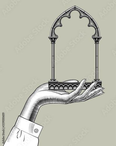Engraved vintage drawing of  female hand holding a classic gothic architectural decorative frame