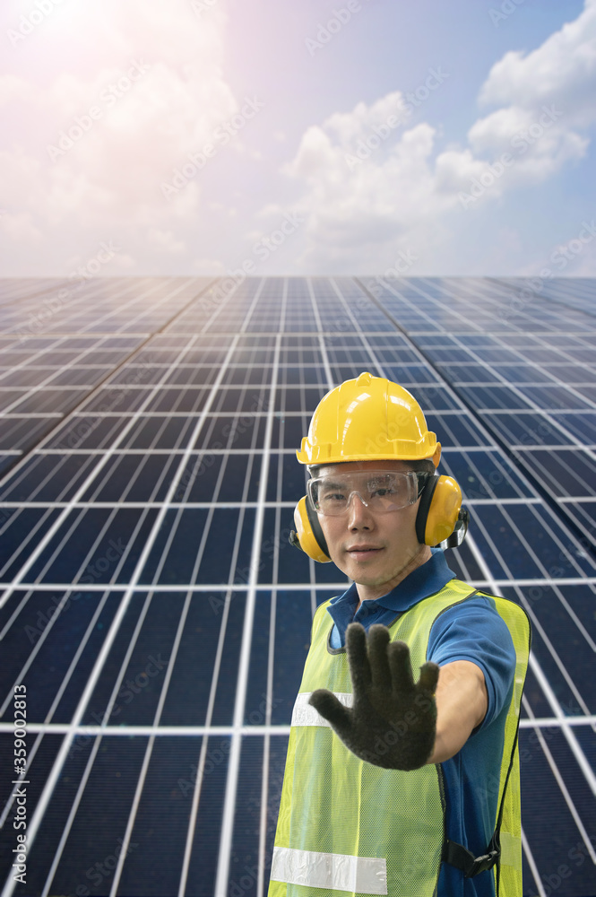 Solar cell panel blue sky and Asian worker staff engineer lift his hand prohibit signal Solar cell panel blue sky and Asian worker staff engineer lift his hand prohibit signal