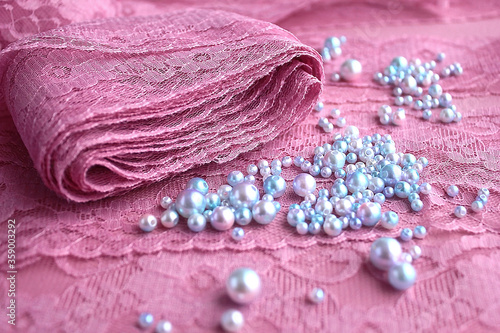 Foto A skein of pink purple guipure lace along with lilac 
blue pearls beads for embr