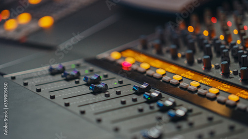 Modern Music Record Studio Control Desk with Equalizer, Mixer and other Professional Equipment. Switchers, Buttons, Faders, Sliders, Motorized Faders Move, Record, Play Hit Song. Close-up 