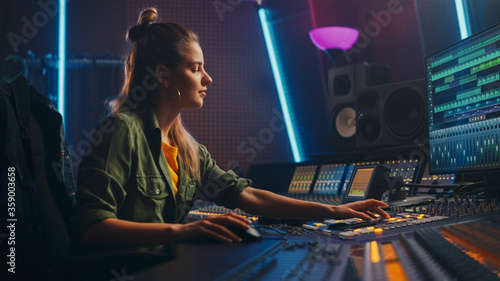 Female Audio Engineer Working in Music Recording Studio, Uses Mixing Board Create Song. Successful Girl Artist Musician Working at Control Desk. Having Fun, Smiling.