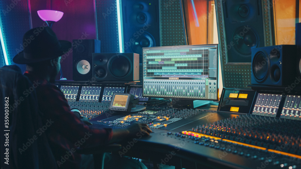 Portrait of Audio Engineer Working in Music Recording Studio, Uses Mixing Board Create Modern Sound. Successful Black Artist Musician Working at Control Desk. - obrazy, fototapety, plakaty 