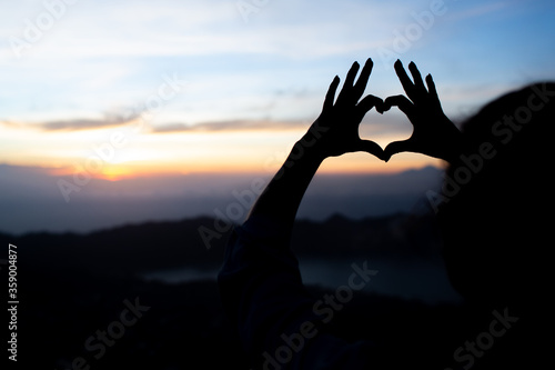 girl shows heart with her hands. on the volcano batur. bali. Indonesia