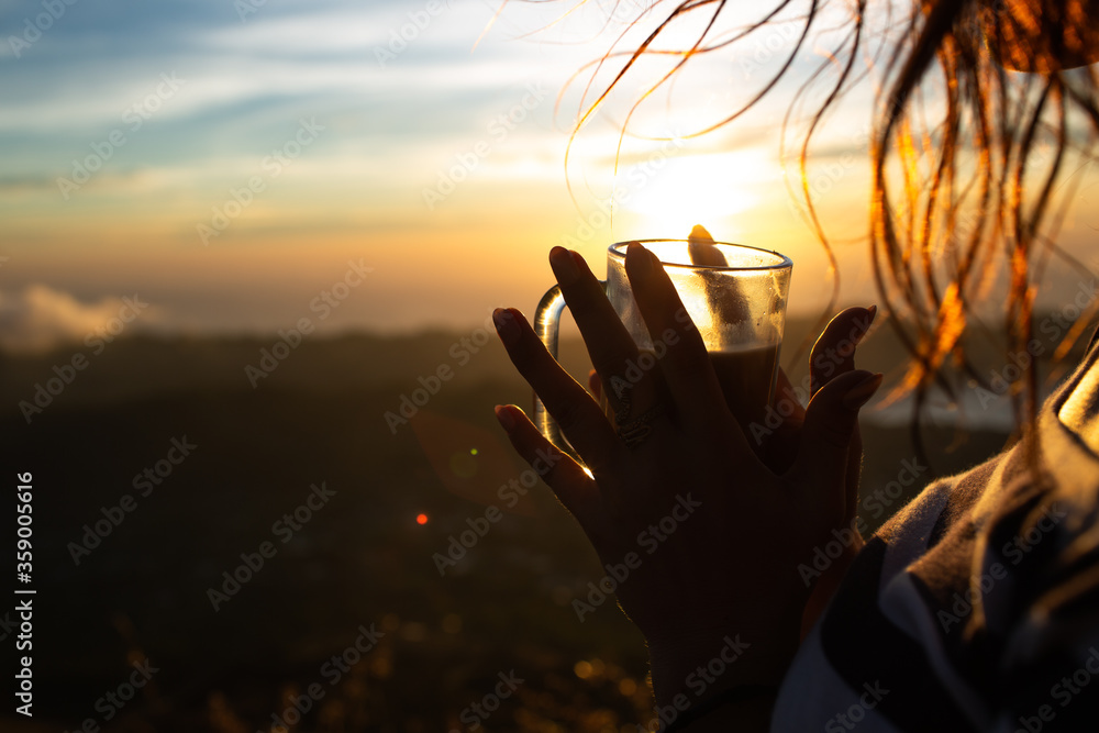 close-up. girl drinks coffee at dawn on the volcano Batur. Bali Indonesia