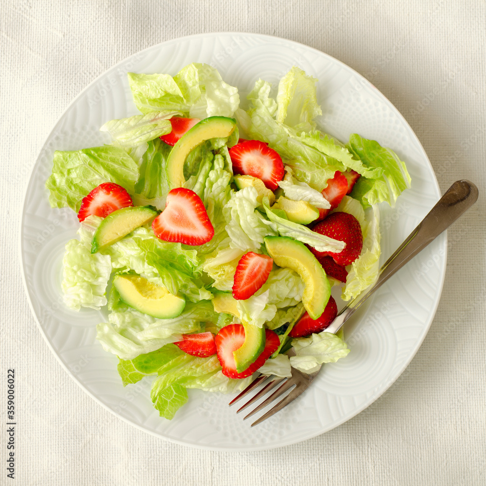Salad with avocado, strawberries and lettuce on white background Salad with avocado, strawberries and lettuce on white background