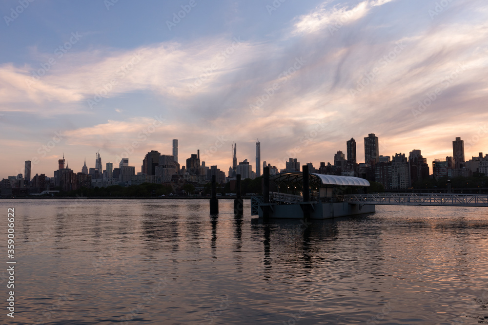 Astoria Queens Ferry Boat Stop with a Colorful Sunset over the Roosevelt Island and Manhattan Skyline along the East River in New York City