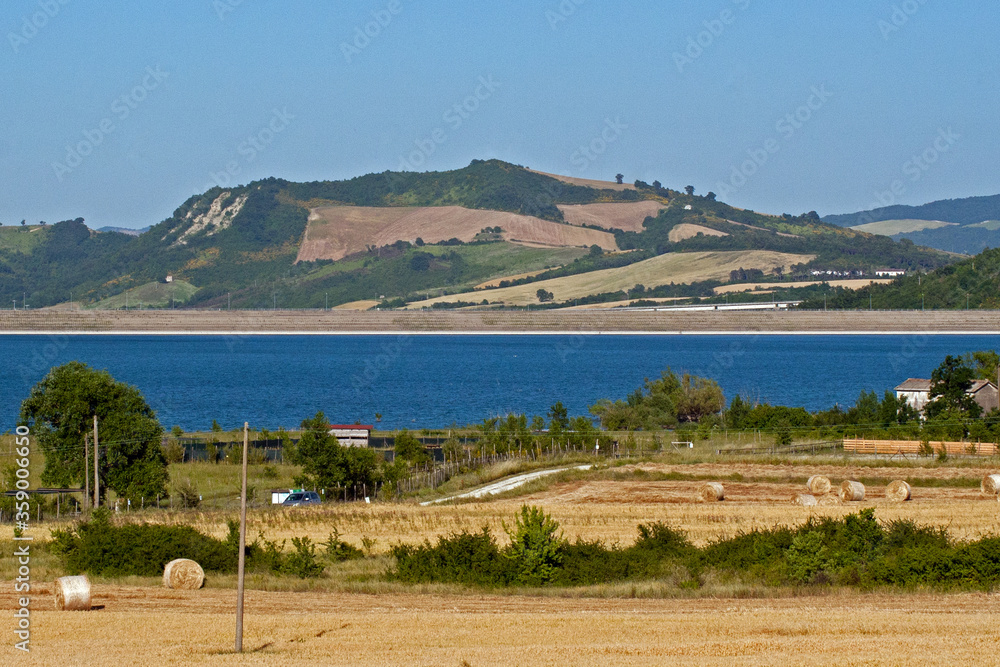 landscape with the lake of Conza della Campania and cultivated fields on the hill. Campania, Irpinia, Avellino, Italy.