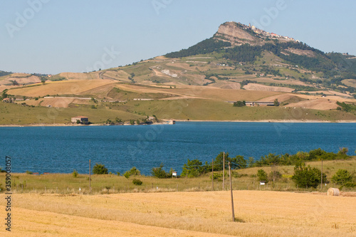 landscape with the lake of Conza della Campania ,cultivated fields on the hill and the village of Cairano. Campania, Irpinia, Avellino, Italy. photo