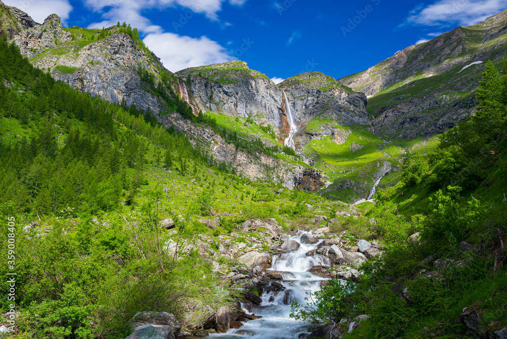 Scenic waterfall and mountain river on the italian Alps. Tourism destination hiking outdoors activity. Pis waterfall near Torino, Piedmont, Italy