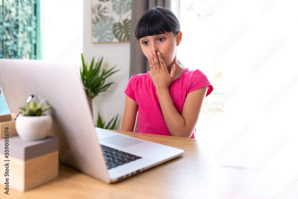 girl watching something surprising on a computer at home girl watching something surprising on a computer at home