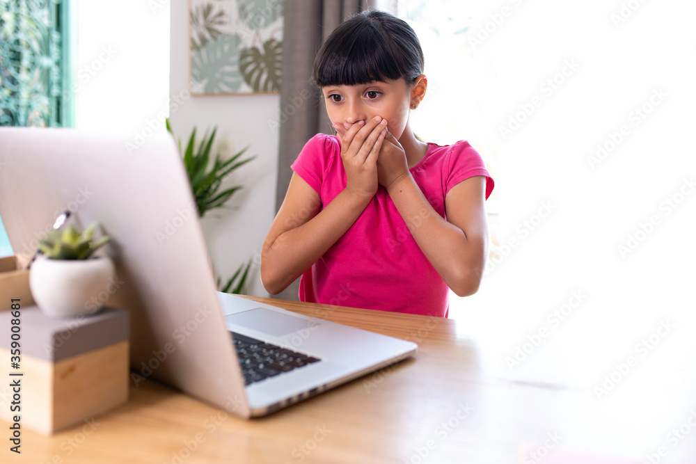 girl watching something surprising on a computer at home girl watching something surprising on a computer at home