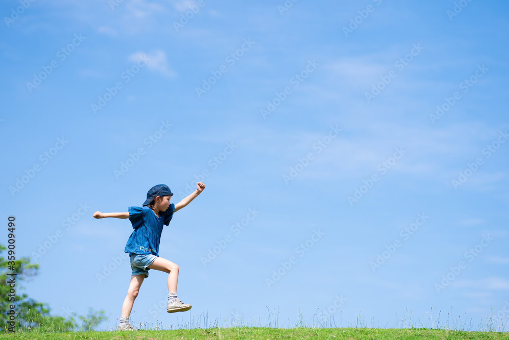 青空の下で元気に歩く子供