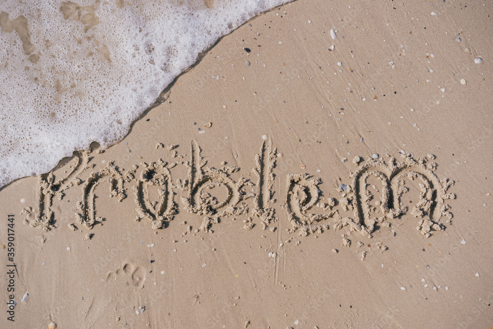 Fototapeta premium the word problem written in sand that is washed off by a sea wave 