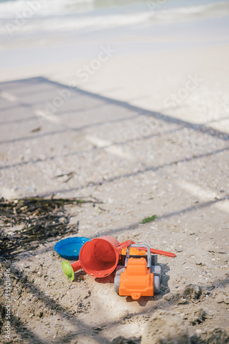 children's multi-colored toys in the sand near the sea 