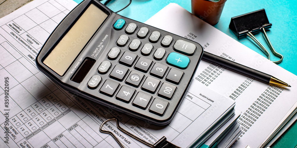 Folded business papers, calculator, pen and paper clips on the office desk. Business concept Folded business papers, calculator, pen and paper clips on the office desk. Business concept