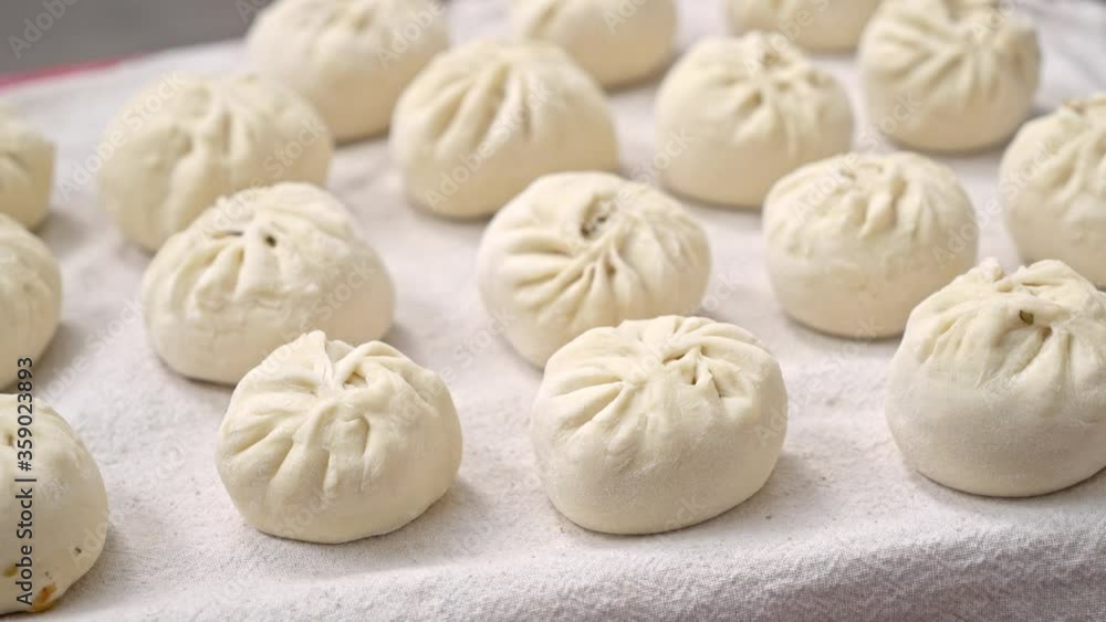 Raw uncooked meat buns on white table, homemade food, focus on foreground Raw uncooked meat buns on white table, homemade food, focus on foreground