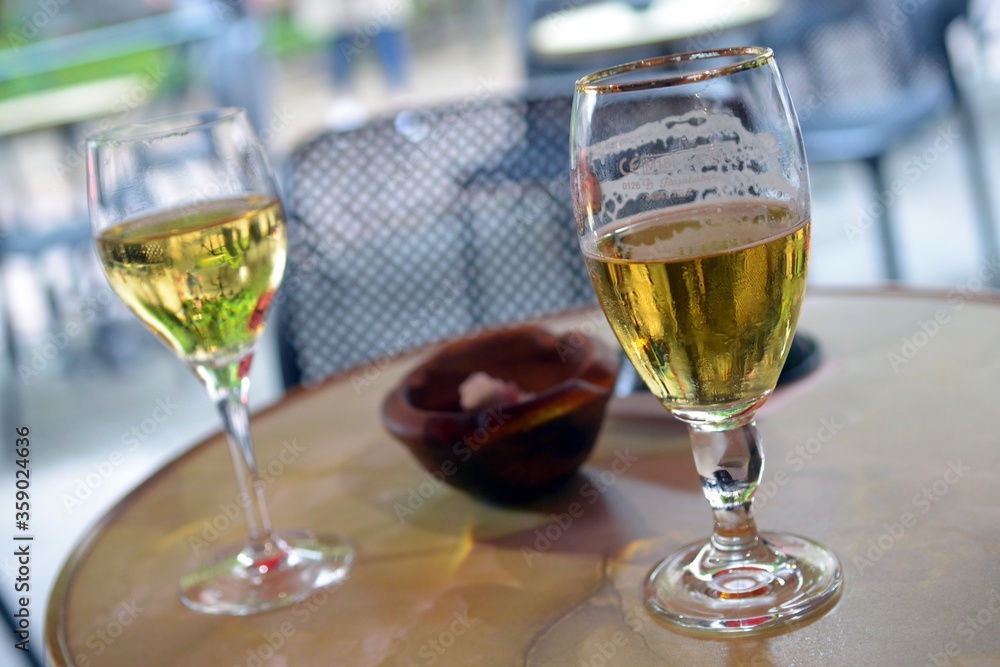 Naklejka premium Verre de bière et verre de vin blanc sur une table