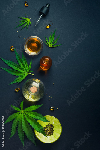 Medical CBD oil on black trendy background with cannabis leaves. The concept of medical tincture of marijuana. Trendy Flat Lay Minimalism