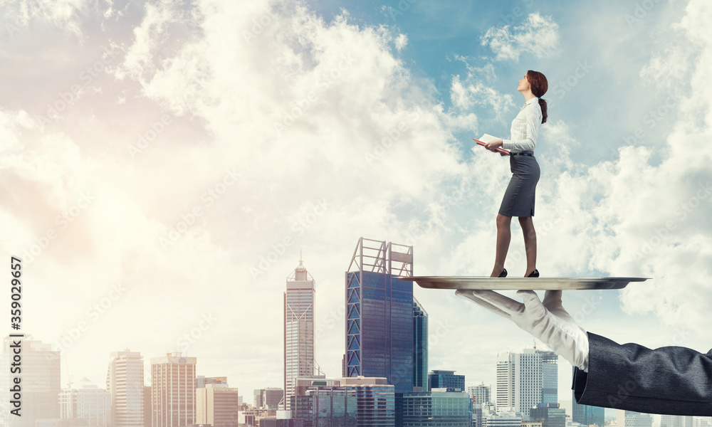 Attractive businesswoman on metal tray with red book in hands against cityscape background Attractive businesswoman on metal tray with red book in hands against cityscape background
