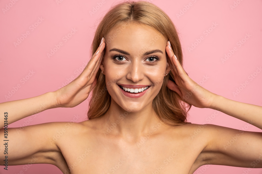 Portrait of happy girl, smiling broadly wiht wide open big eyes holding her head isolated on pink background Portrait of happy girl, smiling broadly wiht wide open big eyes holding her head isolated on pink background