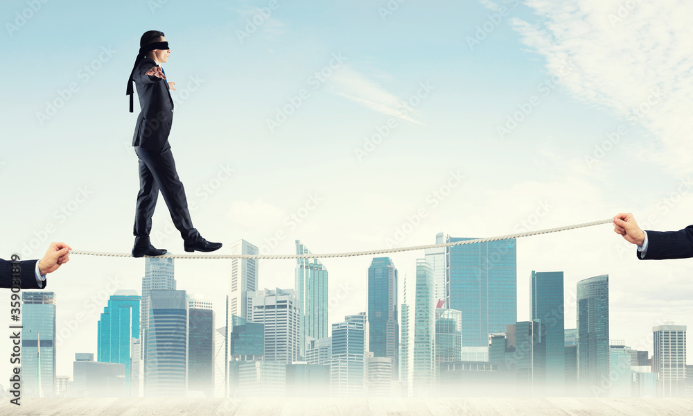 Business concept of risk support and assistance with man balancing on rope Business concept of risk support and assistance with man balancing on rope