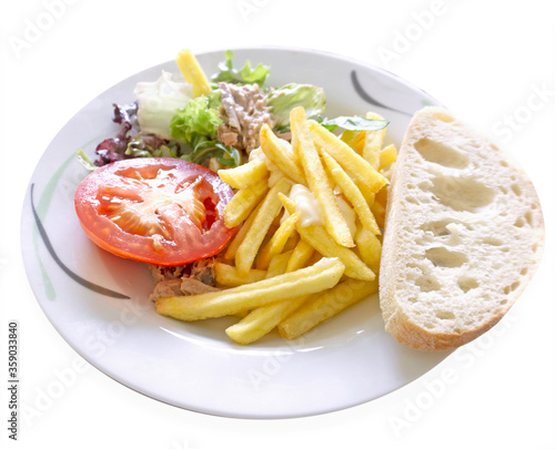 Plate of food. French fries, tomato, salad and bread. Isolated image on a white background. 