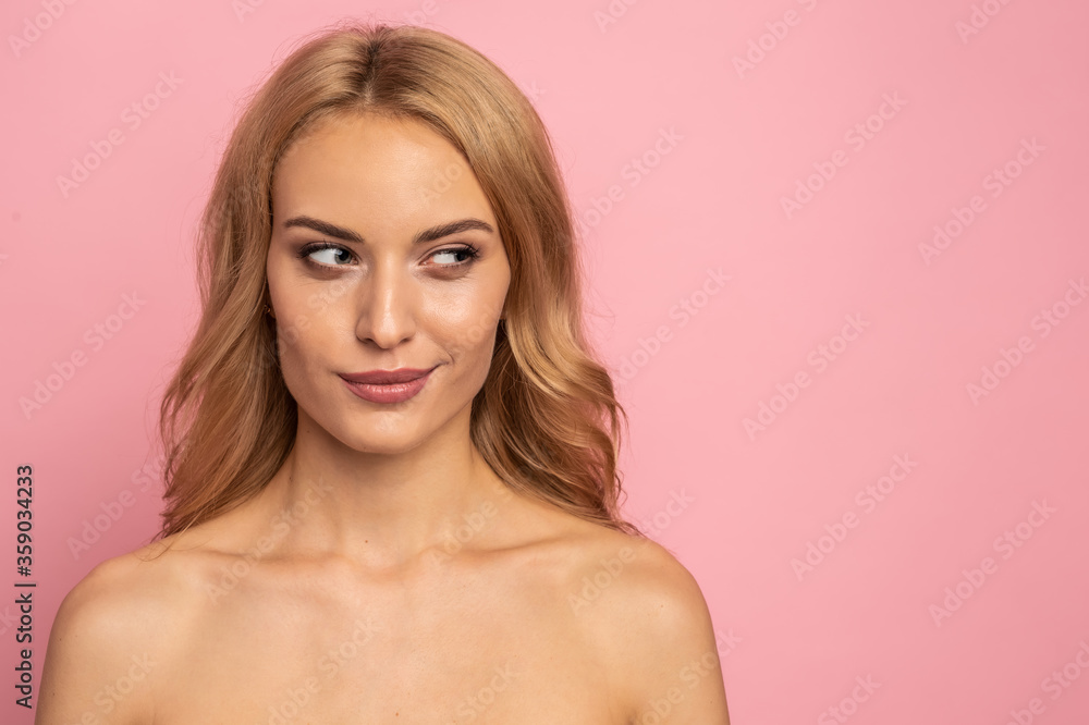 Beautiful sensual topless woman with long blonde hair posing isolated over pink background. Beauty concept. Looks towards free space for advertising, text or logo Beautiful sensual topless woman with long blonde hair posing isolated over pink background. Beauty concept. Looks towards free space for advertising, text or logo