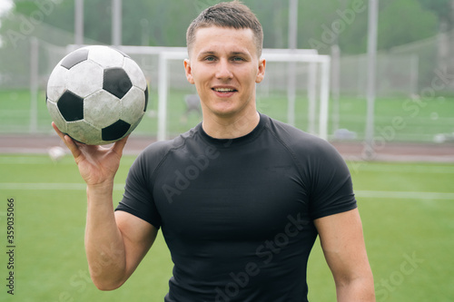 Portrait of a handsome man with a smile holding soccer ball. The concept of advertising a football club. ©  drugoenebo