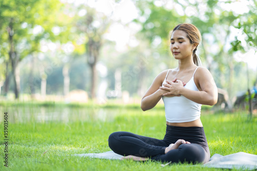 Portrait of young woman practicing yoga in garden.female happiness. blurred background.Healthy lifestyle and relaxation concept.Young Asian Girl doing yoga in the park.
