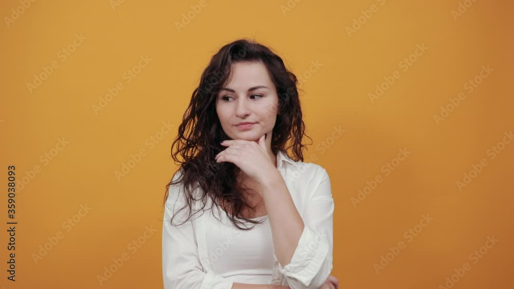 Hand on chin thinking about question, pensive expression. Doubt. Thoughtful face. Using that incredibly sharp business mind. Young attractive woman, dressed white blouse, with brown eyes, curly hair Hand on chin thinking about question, pensive expression. Doubt. Thoughtful face. Using that incredibly sharp business mind. Young attractive woman, dressed white blouse, with brown eyes, curly hair