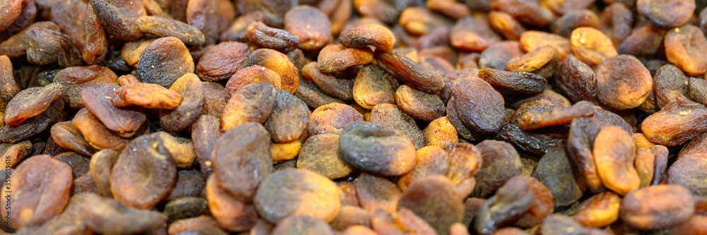 black dried apricots a pile of dry fruits as a background. banner black dried apricots a pile of dry fruits as a background. banner