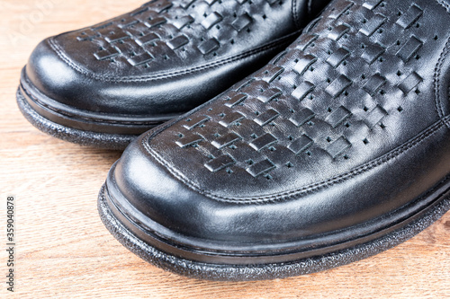 New black men shoes on wooden background. Elastic sided shoes. Side gusset shoes. Lazyman shoes. Side view. Closeup photo