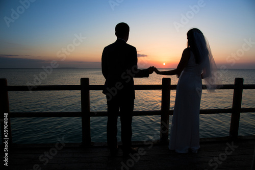 Wedding couple silhouette against sunset and blue sky